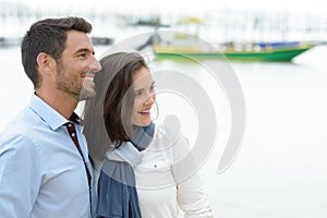 Couple looking into distance by harbour