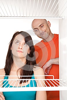 Couple looking in empty fridge