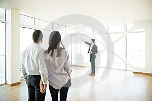 Couple Looking At Estate Agent Showing Window Of New Apartment