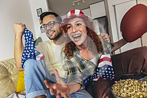 Couple looking excited and happy after their favorite football team scored a touchdown