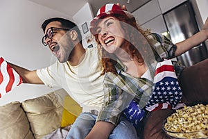 Couple looking excited and happy after their favorite football team scored a touchdown