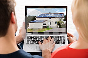 Couple Looking At House On Laptop