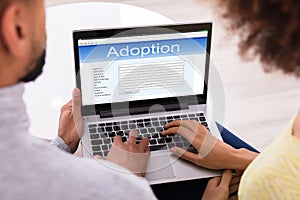 Couple Filling Adoption Paternity Registry In Laptop photo