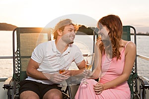 Couple looking lovely on each other during sunset on yacht