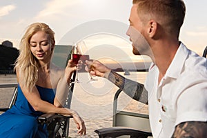 Couple looking lovely on each other on the yacht, and drinking w