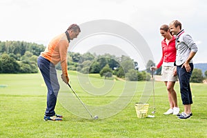 Couple looking at male coacher taking a shot