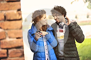 Couple looking at a mobile phone and listening music