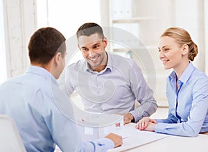 Couple looking at model of their house at office