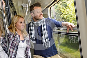 Couple looking out the train window smiling