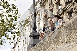 Couple Looking Over Bridge With Guidebook photo