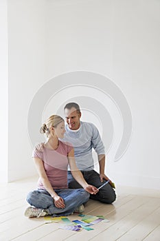 Couple Looking At Paint Swatches On Floor