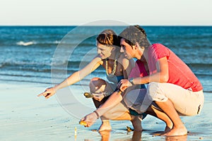 Couple looking for shells at sunset