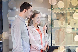 Couple looking to shopping window at jewelry store