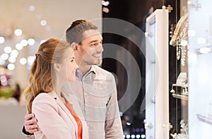 Couple looking to shopping window at jewelry store