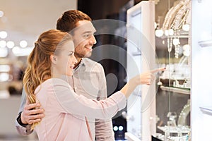 Couple looking to shopping window at jewelry store