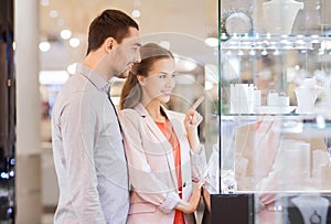 Couple looking to shopping window at jewelry store