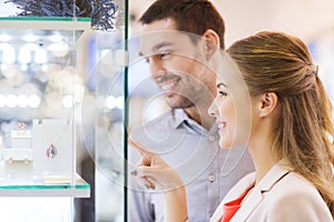 Couple looking to shopping window at jewelry store