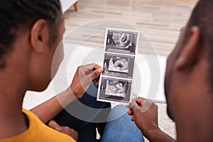 Couple Looking At Ultrasound Scan Report