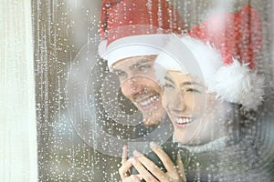 Couple looking through a window in christmas