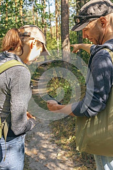 Couple lost in forest. Man and woman with mobile guide in woods. Wanderlust in autumn forest. Looking for direction.