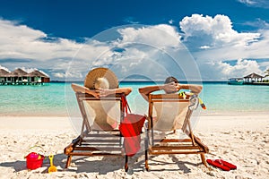 Couple in loungers on beach at Maldives