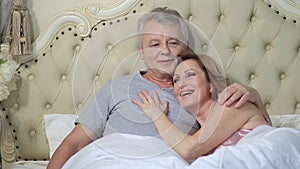 Couple lounging in bed after awaking cuddling