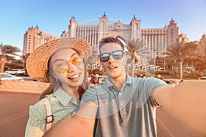couple in love arrived for their honeymoon in Dubai and takes a selfie in front of their hotel on the island of palm Jumeirah
