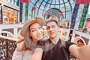 Couple in love - Asian girl and a European man take a selfie in a shopping Mall in the United Arab Emirates. Holidays and