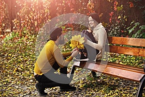 Couple in love in autumn park at bench.