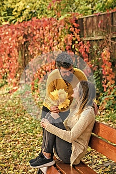 Couple in love in autumn park at bench.