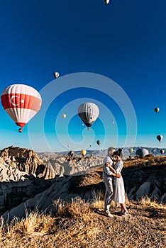 Couple in love among balloons. A man proposes to a woman. Couple in love in Cappadocia. Couple in Turkey.