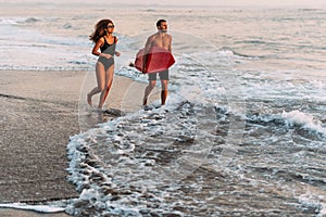 A couple in love on the beach. Surfing in Bali Indonesia. Couple of surfers walking on coast in Indonesia. Couple in love