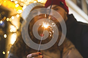 Couple in love in blur with christmas sparkler
