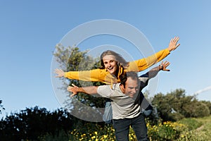 Couple in love. Boyfriend carrying his girlfriend on piggyback. Love and tenderness, dating, romance. Lifestyle concept