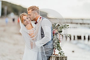 Couple in love. Bride and groom kiss and hug on the beach