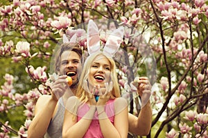 Couple in love with bunny ears holding colorful eggs