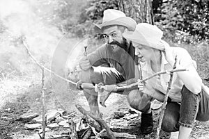 Couple in love camping forest roasting sausage at bonfire. Couple hungry tourists roasting sausages on sticks nature