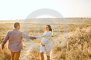 Couple in love caucasian man and woman holding hands outdoors