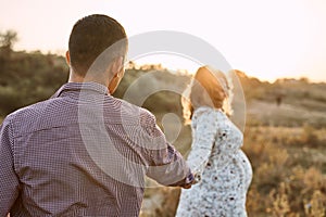 Couple in love caucasian man and woman hugging holding hands outdoors