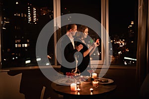 Couple in love celebrating valentine& x27;s day dinner with candles, anniversary or date at night in a restaurant, dark
