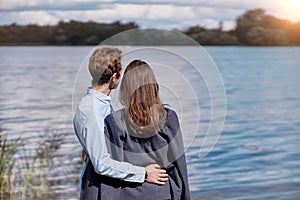 couple in love is chatting standing on the shore of the lake .