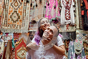 Couple in love chooses a Turkish carpet at the market. Cheerful joyful emotions on the face of a man and a woman. Valentines Day