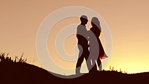 Couple in love dancing silhouette at sunset nature and kissing. Loving man and woman with dog dancing silhouette slow