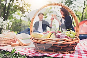 Couple in love drink a orange juice and fruits on summer picnic, leisure, holidays, eating, people and relaxation concept