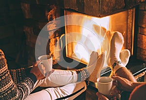 Couple in love drink a tea near fireplace. Cozy christmas home a
