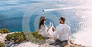 A couple in love drinking champagne on the seashore, panorama. A happy couple on a honeymoon by the sea, panorama.