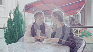 Couple in love drinking coffee on romantic date in cafe outdoors