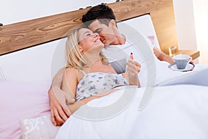 Couple in love drinking morning coffee in bed