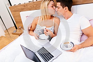 Couple in love drinking morning coffee in bed