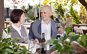 Couple in love drinking red wine at open-air restaurant